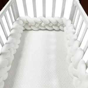 Tour de lit tressé blanc pour bébé dans un berceau