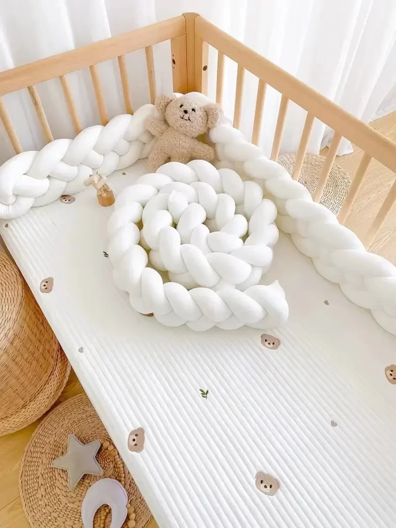 Tour de lit tressé blanc pour bébé enroulé dans un berceau