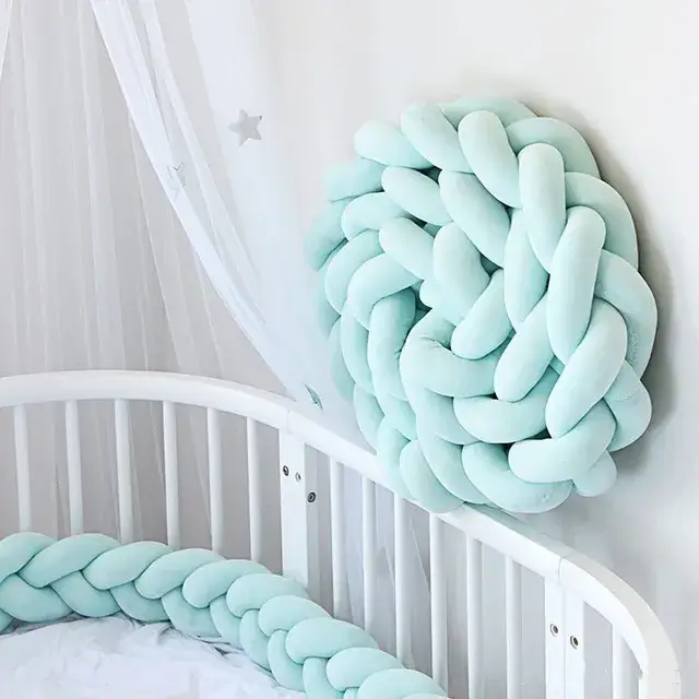 Tour de lit tressé bleu pour bébé dans un berceau